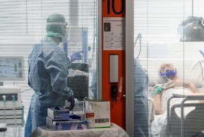 Medical workers wearing a face make and protection gear tend to a patient inside the new coronavirus intensive care unit of the Brescia Poliambulanza hospital as the town saw the country's highest daily rise in case numbers