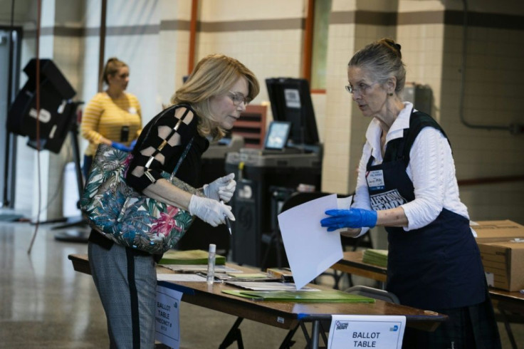 An election worker assists a voter during the Democratic presidential primary election at Doris &  Phil Sanford Fire Rescue Station Coral Gables in Miami, Florida