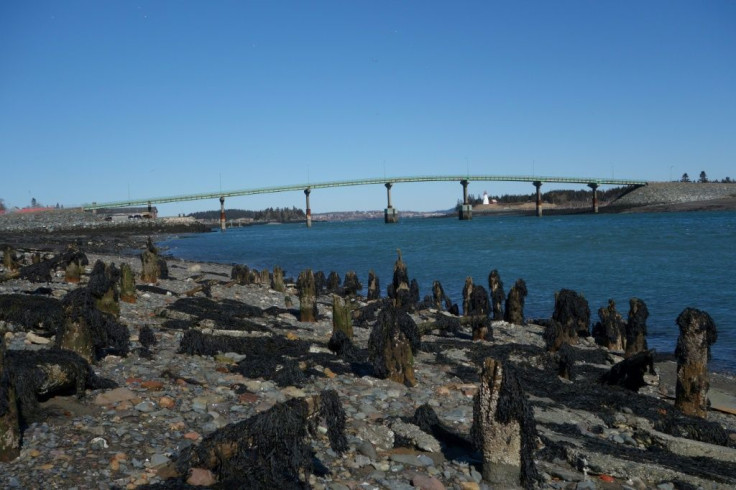 Cars cross over the International Bridge from the US state of Maine (left) on the US-Canada border, which the US is closing to "non-essential" traffic