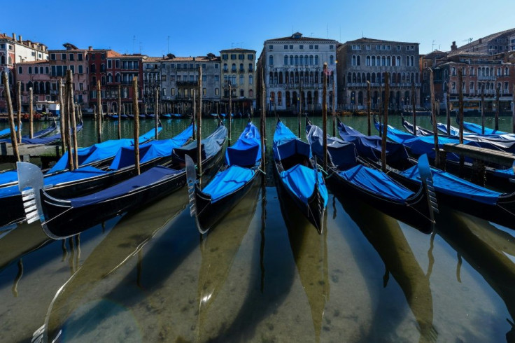 Gondolas sit empty in Venice's Grand Canal with Italy in lockdown to confront the dire impact of new coronavirus which, in one day, killed 475 more people in the country