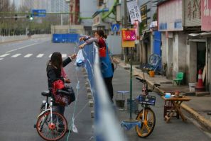 Barriers to stop the spread of the coronavirus in Wuhan have divided communities