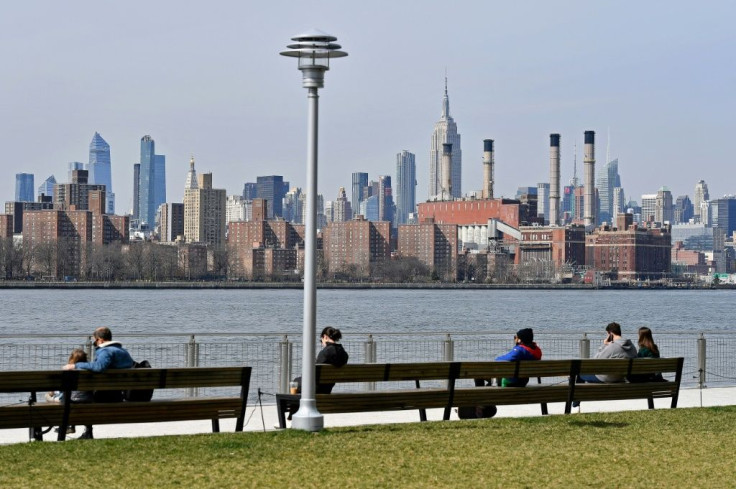 People sit apart on a park bench with a view of Manhattan, as most of New York is shut down in a bid to slow the spread of coronavirus