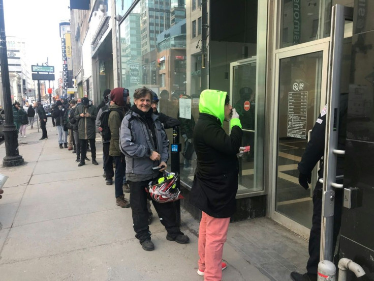 Cannabis consumers line up outside a Montreal sales point for the mood-altering drug March 18, 2020