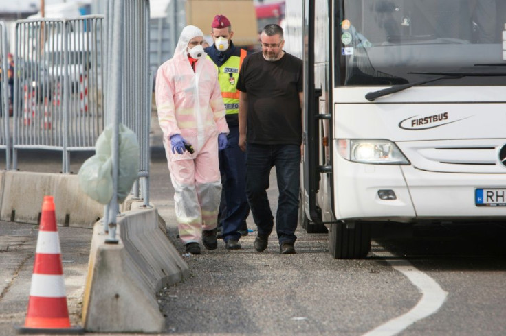 Hungarian police and medics control passengers on a bus at the border -- huge tailbacks have ensued since Budapest shut its borders Monday, albeit the rules seemed to be being applied arbitrarily in at least some cases