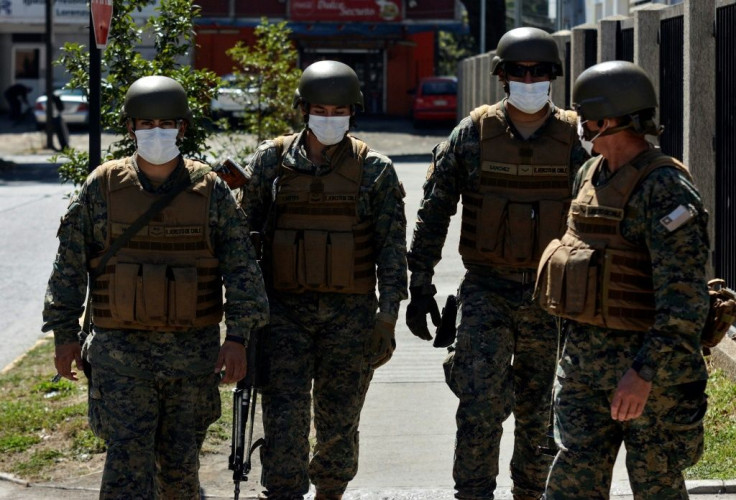 Soldiers wear face masks as they stand guard outside a medical center in Concepcion, Chile, on March 19, 2020