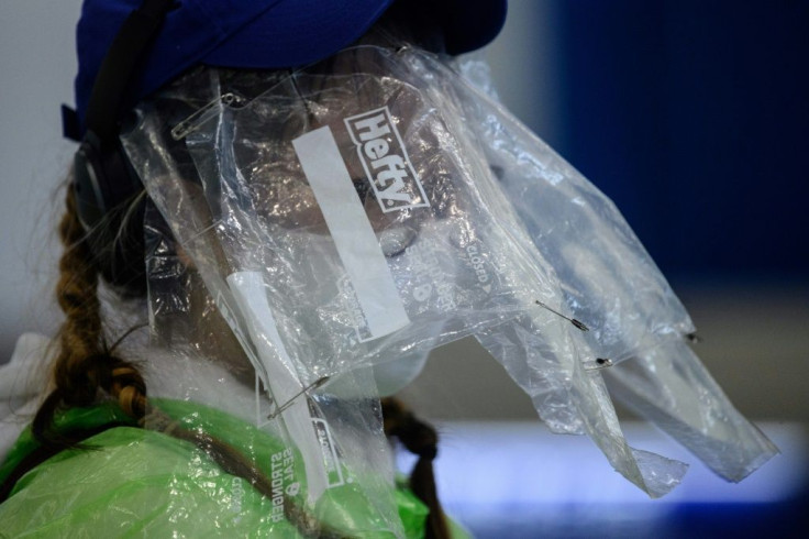 A passenger wears plastic bags over her face to protect against infection at Hong Kong's airport