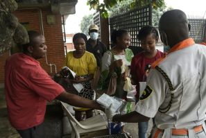 Visitors to a state hospital in Lagos collect facemasks and gloves and have their hands sanitised
