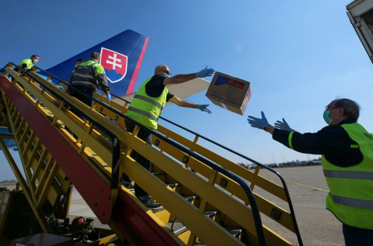 Police in Slovakia unload a plane after it touched down from China with testing kits and masks