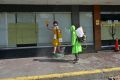 A city worker in a protective suit disinfects a street, as a preventive measure against the COVID-19 coronavirus, next to a closed McDonalds fast-food restaurant in Manila