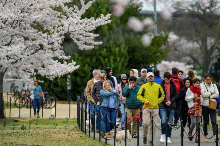 Visitors walk along the Tidal Basin on March 21 as the National Park Service  announced traffic controls and closed parking in an attempt to prevent crowding