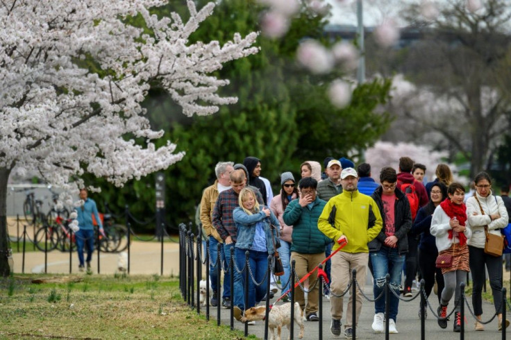 Visitors walk along the Tidal Basin on March 21 as the National Park Service announced traffic controls and closed parking in an attempt to prevent crowding