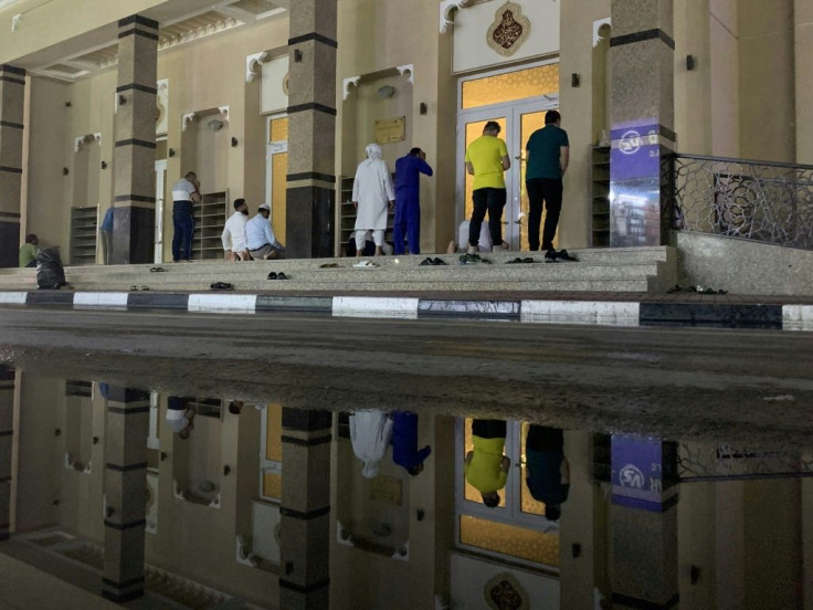 Muslim worshippers pray in front of a Dubai mosque, one of many places of worship across the region to close its doors