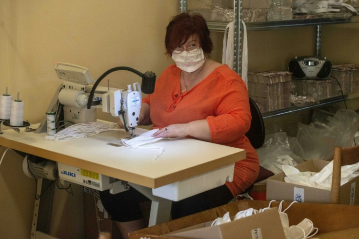 A woman sews masks in the workshop of a small Czech company as tens of thousands of Europeans join forces via social media to combat a dire global shortage