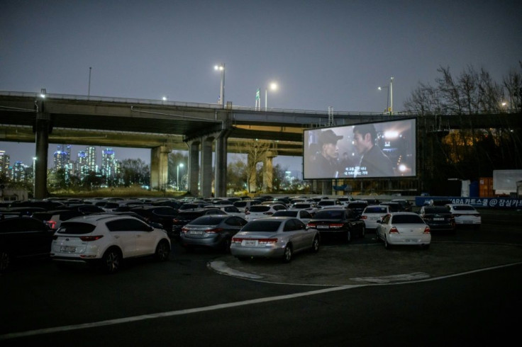 People can park their cars in front of a large outdoor screen
