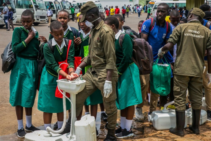 Secondary school students in Rwanda wash their hands at temporary hand washing point before they return home after authorities closed all boarding schools