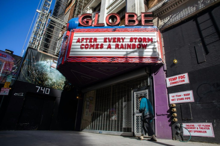 A homeless man walks by a closed theater in Los Angeles, on March 21, 2020, as California  grapples with its part of the global coronavirus pandemic