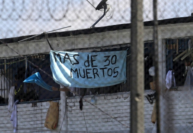 Inmates at Bogota's La Modelo prison hold up a sign saying, "More than 30 Dead" after a night of rioting in one of Colombia's biggest prisons, on March 22, 2020