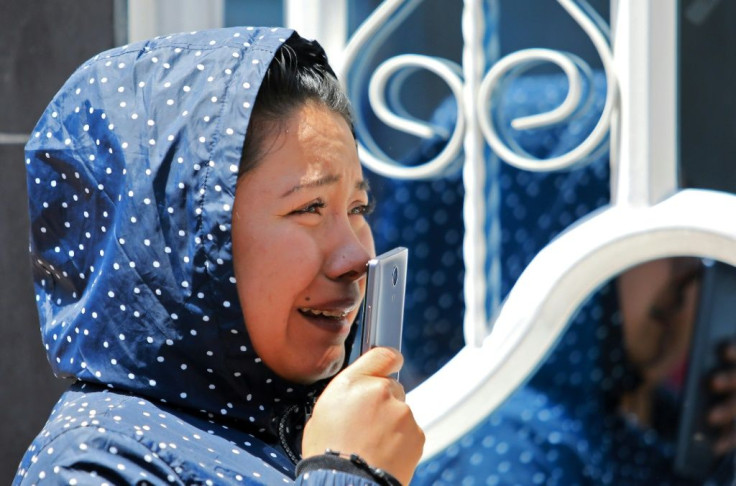 A crying relative of an inmate speaks on a mobile phone outside the La Modelo prison after rioting claimed the lives of 23 inmates and wounded dozens, on March 22, 2020