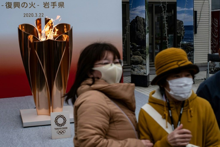 The Olympic torch relay has been altered but large crowds have still gathered to see the flame after it arrived in a scaled-back ceremony