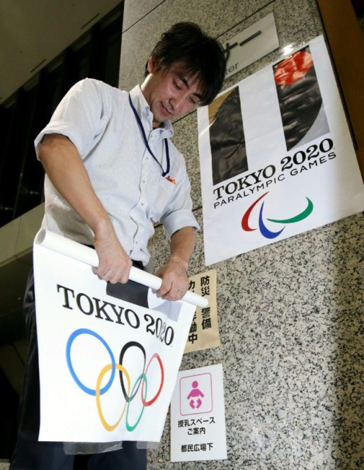 Posters bearing the original logo of the Tokyo 2020 Olympic Games are removed from Tokyo City Hall after the emblem was scrapped in an embarrassing plagiarism scandal