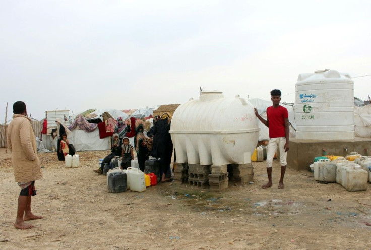 Yemenis fill jerricans with water from reservoirs at a makeshift camp for displaced people who fled fighting between the Huthi rebels and the Saudi-backed government