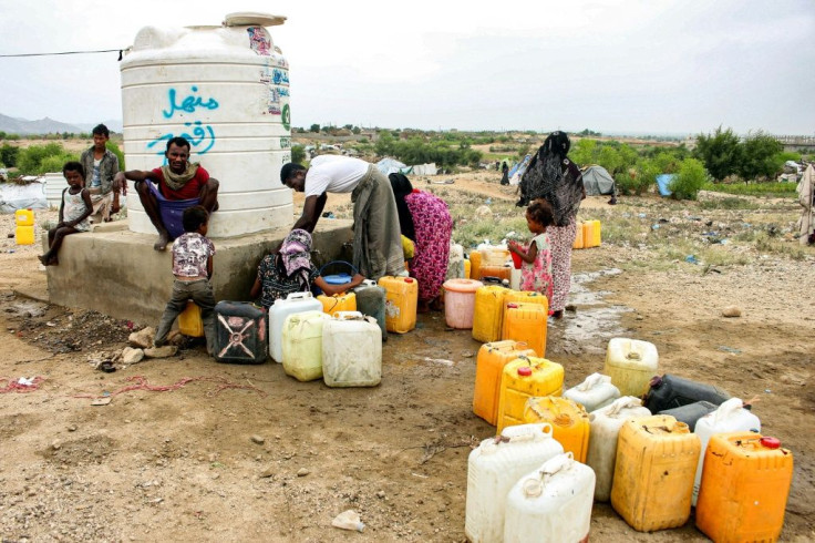 People load up on water from a cistern at a makeshift camp for displaced Yemenis in the northern Hajjah province