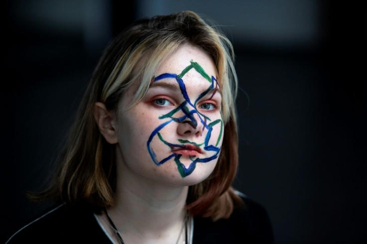 Four activists protested outside the presidential administration offices with their faces brightly painted with geometrical shapes and lines, said to confuse cameras