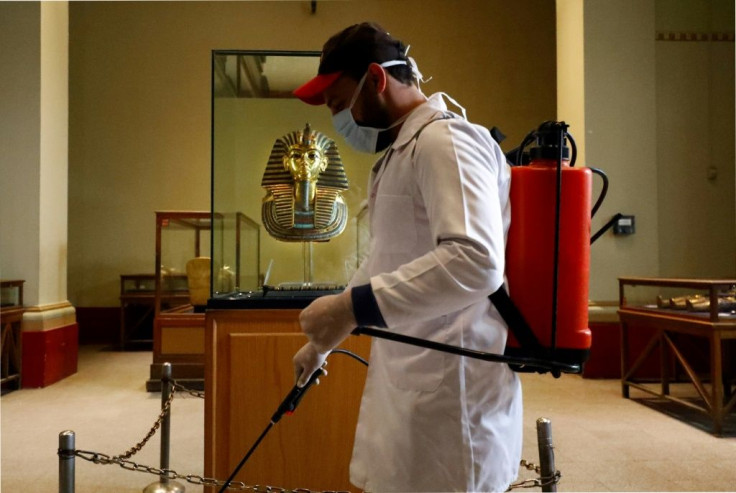 A cleaner disinfects the display case housing the gold funeral mask of famed pharaoh Tutankhamun at the Egyptian Museum in Cairo