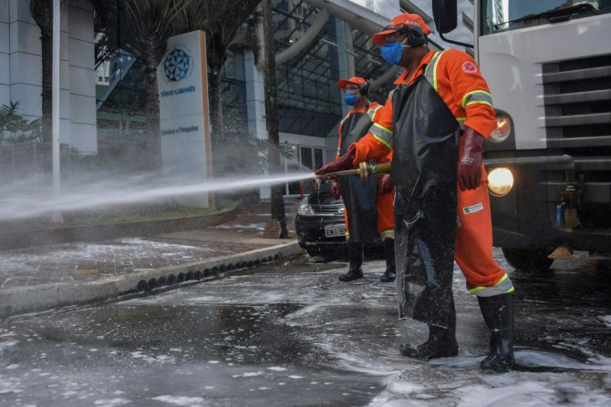Members of a cleaning crew disinfect the streets around the Sirio-Libanes Hospital in Sao Paulo, Brazil, on March 23, 2020