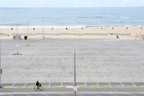 A cyclist rides past an empty parking lot at Santa Monica beach in California -- more than a third of the US population are under stay-at-home orders