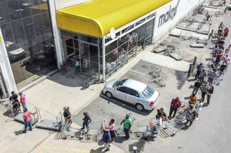 Customers queue outside a super store in Soweto as South Africa enters a 21-day national lockdown