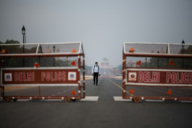 A man walks on a deserted road in New Delhi during an Indian government-imposed lockdown against COVID-19