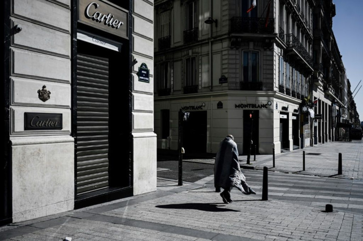 A homeless person walks down the deserted Champs-Elysees in Paris