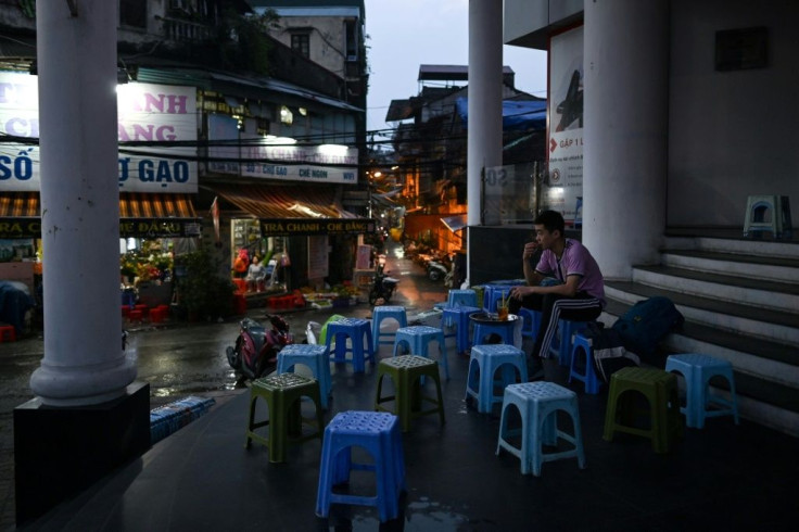 A man sits alone at a street-cafe, amid concerns over the spread of the COVID-19 novel coronavirus, in Hanoi