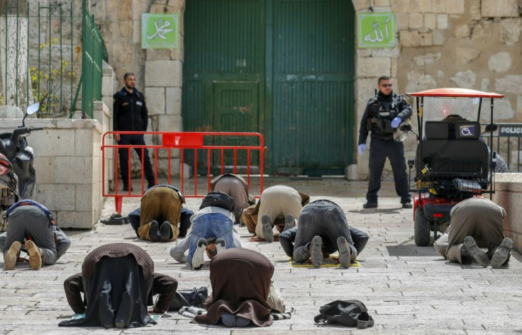 Palestinian Muslim men in prayer near the gate of the Al-Aqsa mosque compound, closed as part of preventive measures against the spread of the coronavirus