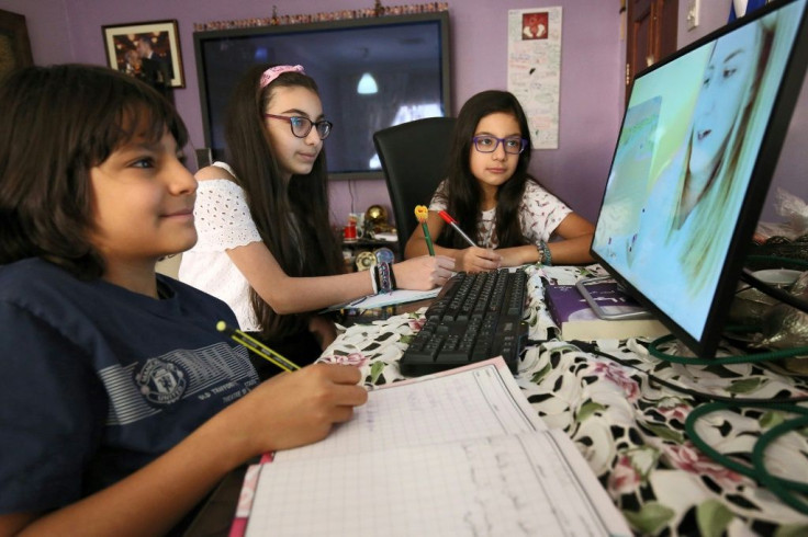 Students attend an online class at home in Kuwait City
