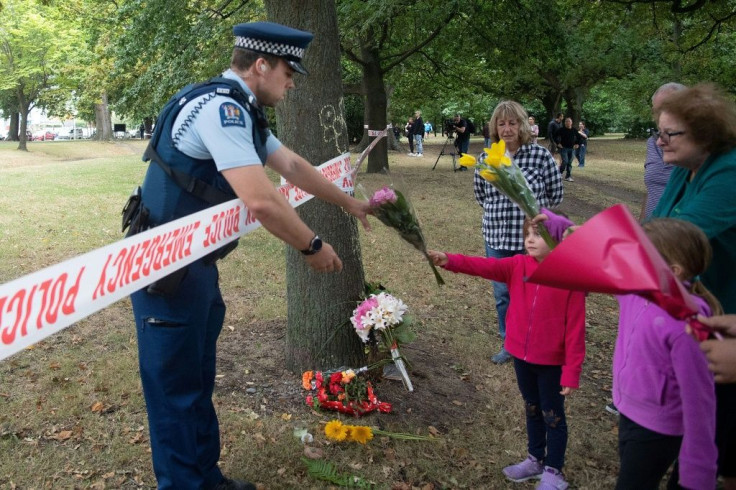 Members of the public hand flowers to a police officer to take over to the Dean Avenue mosque March 17, 2019 in Christchurch, New Zealand