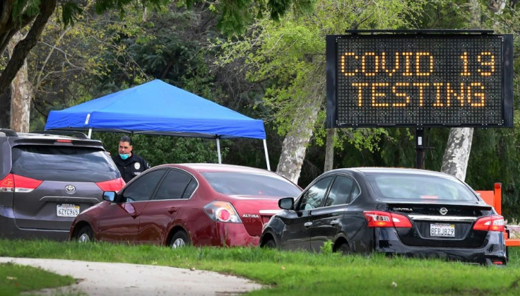 A police officer mans the entrance to a coronavirus (COVID-19) testing center in Hansen Dam Park in Pacoima, California