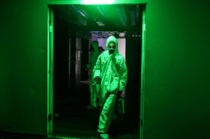 Workers wearing protective clothing disinfect a hotel as a preventive measure against the COVID-19 coronavirus in Yangon, Myanmar