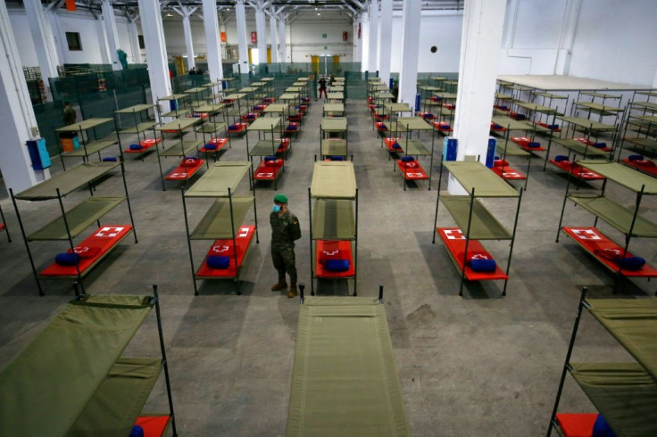 A Spanish soldier stands next to beds set up at a temporary hospital in Barcelona