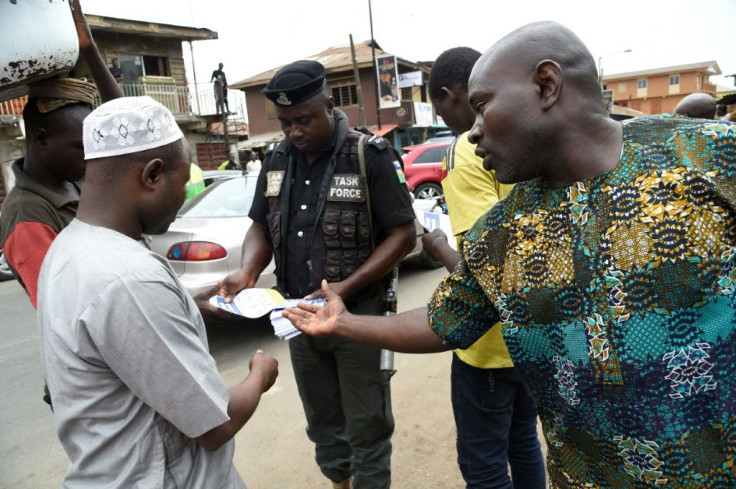 A policeman in Lagos distributes flyers about measures to prevent coronavirus