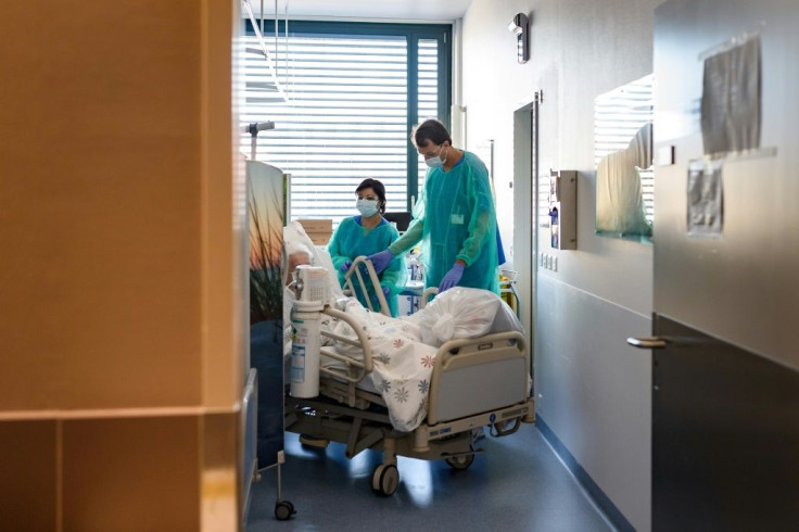 A Swiss soldier (R) helps to move the bed of a COVID-19 patient, at the Pourtales Hospital in Neuchatel on March 25, 2020, after Switzerland deployed its army reservists to relieve hospitals under pressure from the outbreak of COVID-19