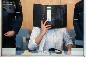 Defendant Sief Allah H. holds a folder in front of his face at the start of his trial on June 7, 2019 at a court in Duesseldorf, western Germany