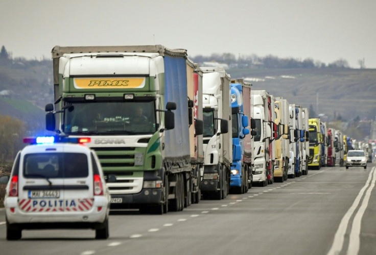 A police car stops delivery trucks for a virus check at the Giurgiu-Ruse border point between Romania and Bulgaria