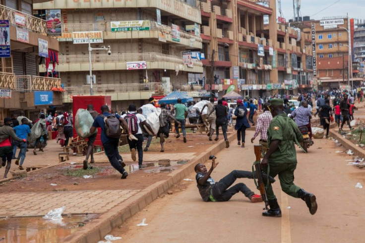 A police officer chases street vendors in Kampala, Uganda, after the public were directed to stay home for 32 days
