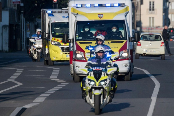 Police officers escort an ambulance carrying patients infected with the covid-19 disease in Nantes, France