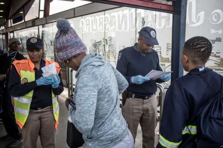 ID check: Papers are scrutinised at a bus station in the Johannesburg suburb of Soweto