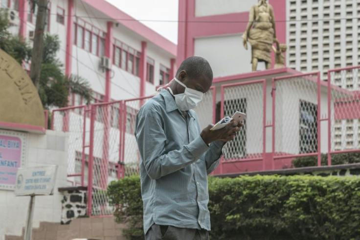 A man wears a mask while walking outside the entrance to the Yaounde General Hospital in Yaounde, Cameroon on March 6