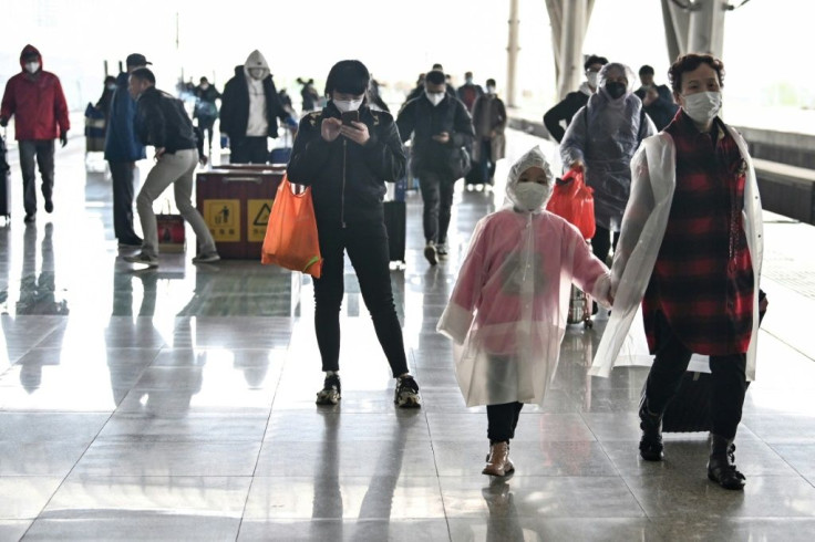 Passengers arrive at the railway station in Wuhan, China's central Hubei province, after travel restrictions into the city were eased following two months of lockdown