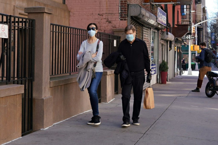 Two people wearing protective masks walk on New York City's Upper East Side as the coronavirus continues to spread